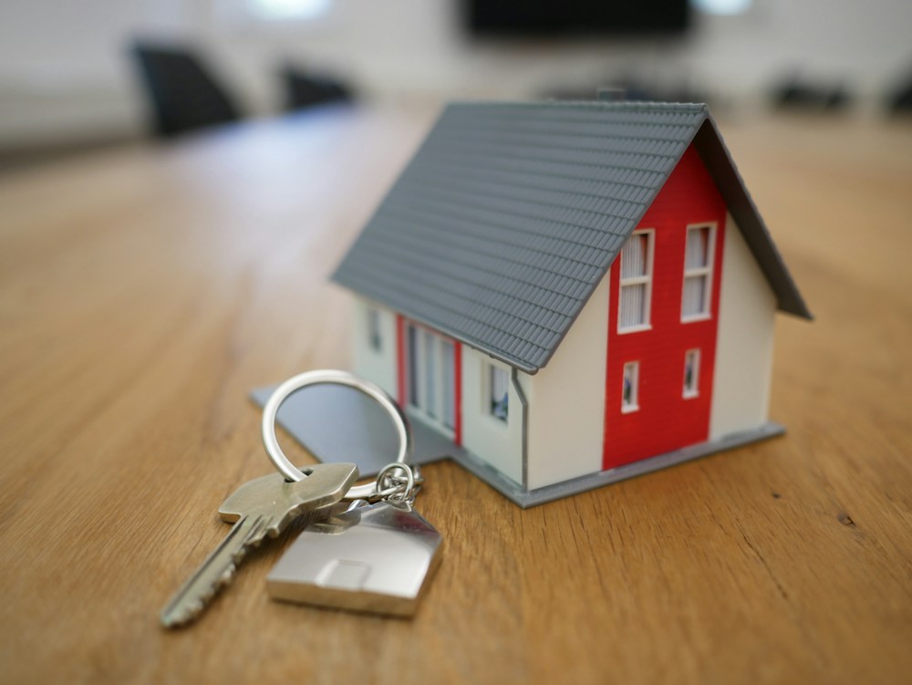A model house and keys on a desk